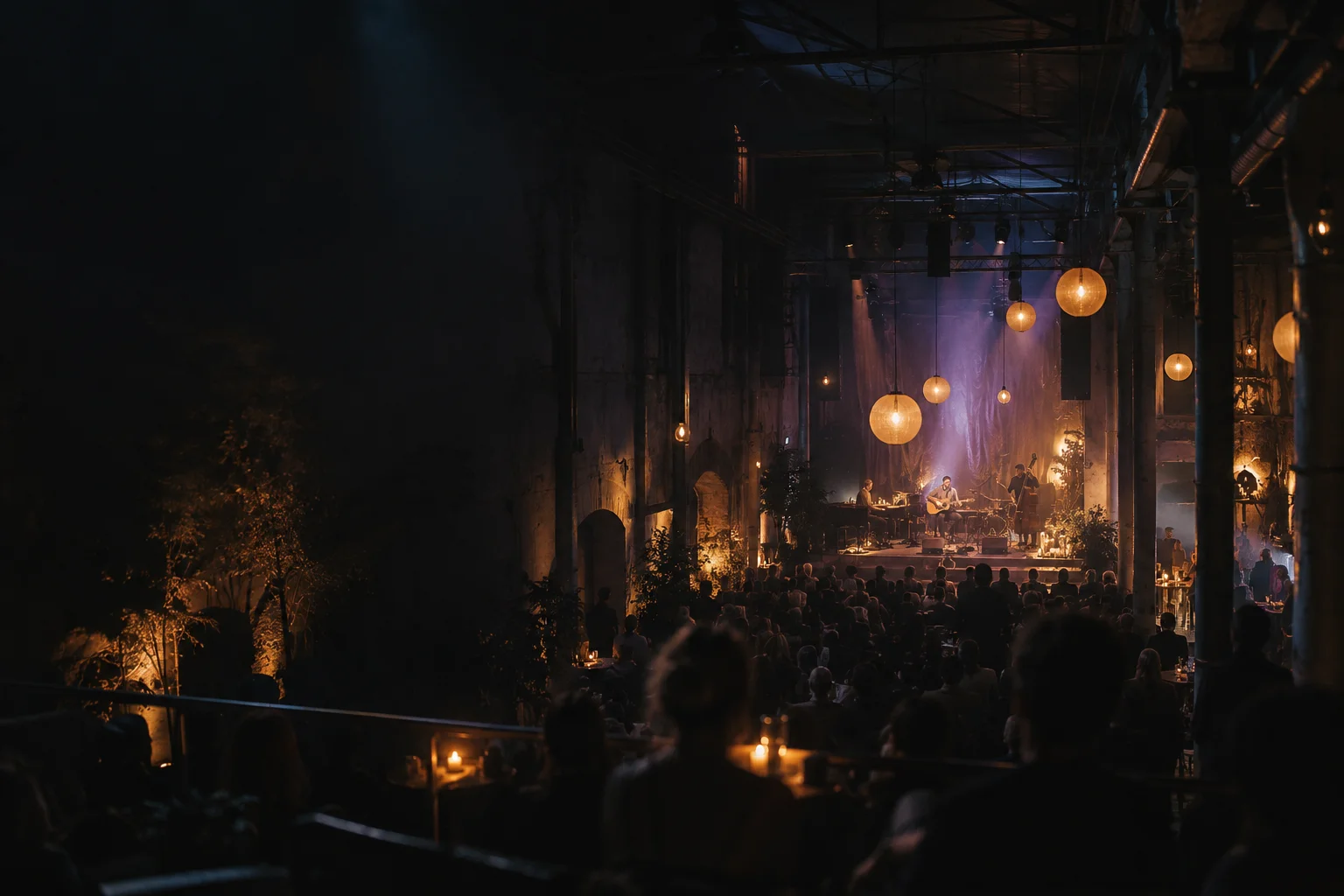Atmosphärisch beleuchtete Eventlocation mit Bühne und Publikum